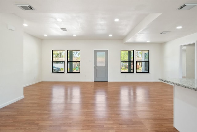 5610 Belarbor St, Houston, TX 77033 - unfurnished living room with visible vents, a healthy amount of sunlight, and light wood-style floors