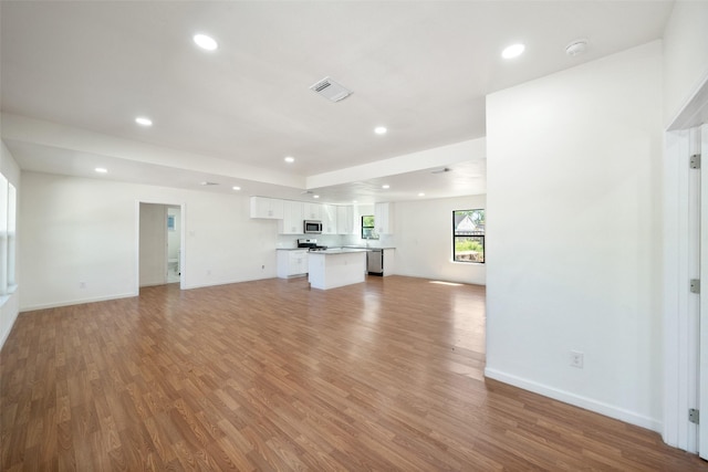 5610 Belarbor St, Houston, TX 77033 - unfurnished living room featuring recessed lighting, visible vents, baseboards, and light wood finished floors