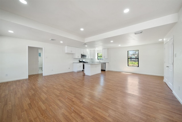 5610 Belarbor St, Houston, TX 77033 - unfurnished living room with light wood-style flooring, recessed lighting, visible vents, and baseboards