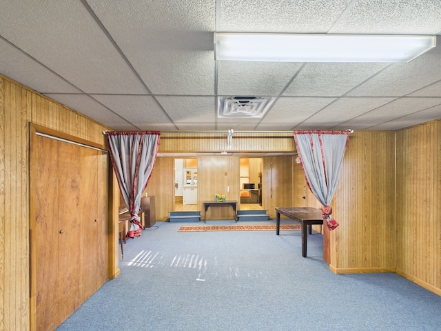 game room with visible vents, wood walls, carpet floors, and a drop ceiling