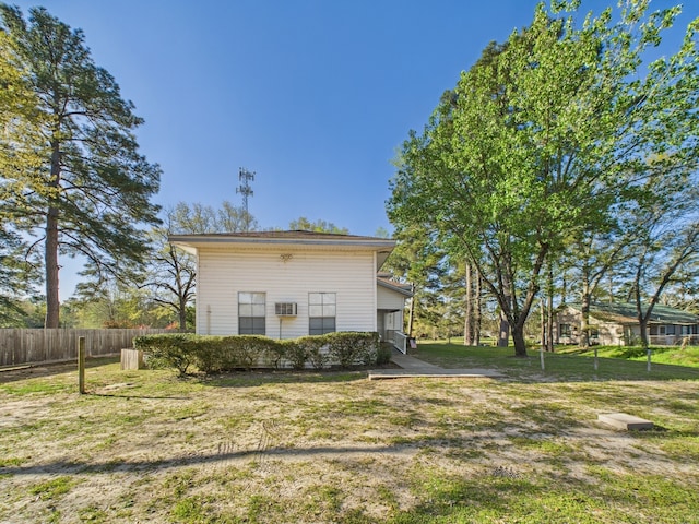 back of house featuring a yard and fence