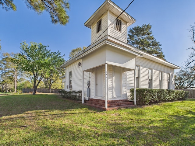 view of front of home featuring fence and a front lawn