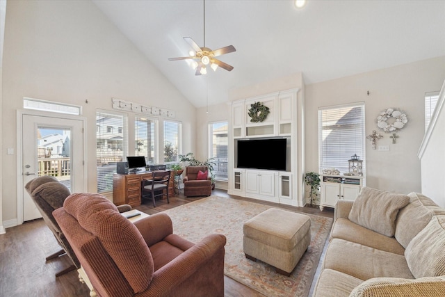 living area with ceiling fan, wood finished floors, a wealth of natural light, and high vaulted ceiling