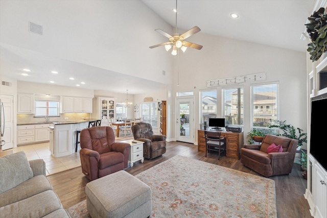 living room with recessed lighting, high vaulted ceiling, visible vents, and ceiling fan with notable chandelier