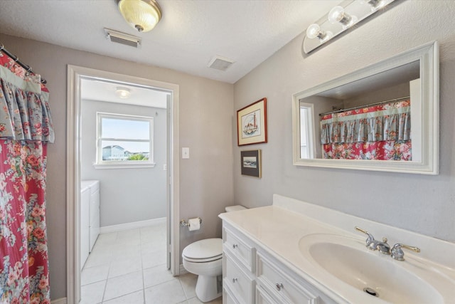 full bathroom featuring washing machine and clothes dryer, tile patterned flooring, vanity, toilet, and visible vents