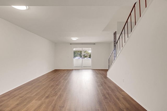 215 Postoffice St Unit 702, Galveston, TX 77550 - unfurnished living room featuring stairway, wood finished floors, and baseboards