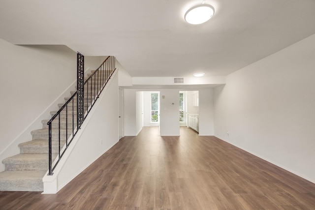 215 Postoffice St Unit 702, Galveston, TX 77550 - unfurnished living room featuring wood finished floors, stairs, and baseboards