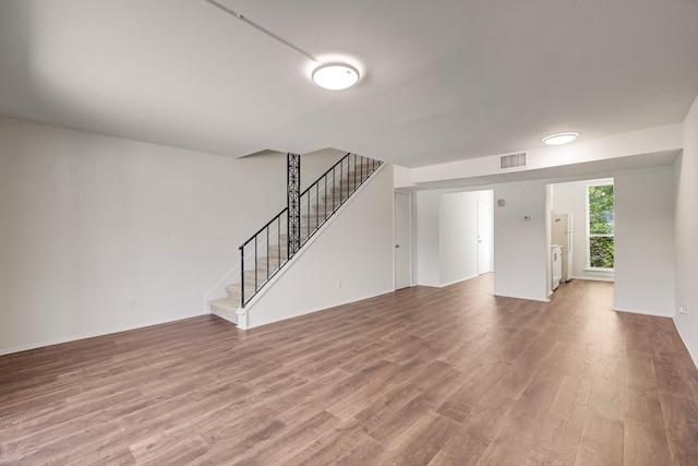 215 Postoffice St Unit 702, Galveston, TX 77550 - unfurnished living room featuring wood finished floors and stairway