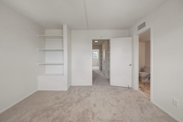 215 Postoffice St Unit 702, Galveston, TX 77550 - unfurnished bedroom with carpet, a textured ceiling, ensuite bathroom, and baseboards