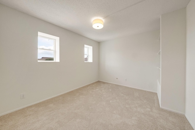 215 Postoffice St Unit 702, Galveston, TX 77550 - empty room with light colored carpet, baseboards, and a textured ceiling