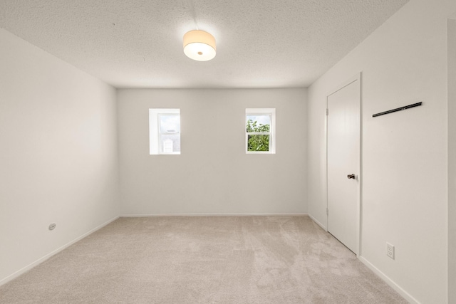 215 Postoffice St Unit 702, Galveston, TX 77550 - unfurnished room featuring light carpet, a textured ceiling, and baseboards