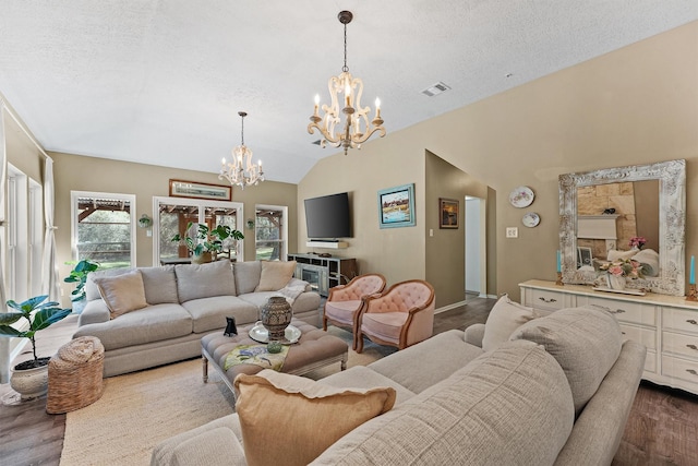 1518 Honea Egypt Rd, Magnolia, TX 77354 - living area featuring visible vents, an inviting chandelier, a textured ceiling, dark wood finished floors, and vaulted ceiling