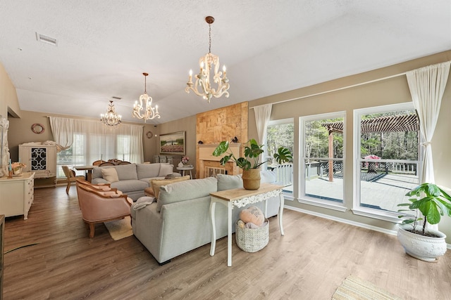 1518 Honea Egypt Rd, Magnolia, TX 77354 - living area featuring a textured ceiling, visible vents, vaulted ceiling, wood finished floors, and a notable chandelier