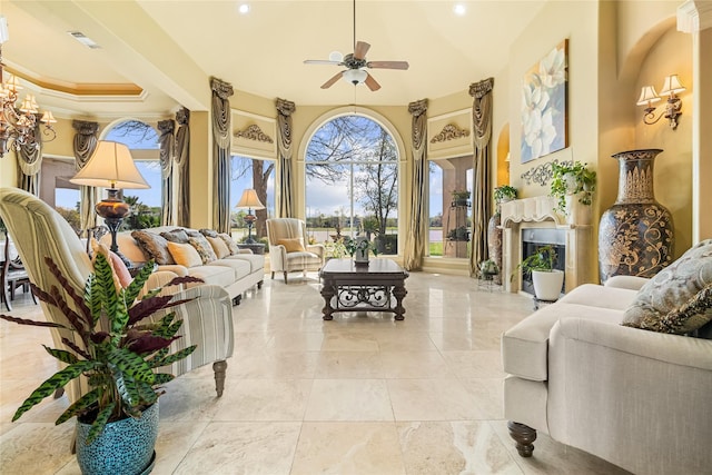 843 Royal Lakes Blvd, Richmond, TX 77469 - living room featuring a tray ceiling, visible vents, a fireplace, and a ceiling fan