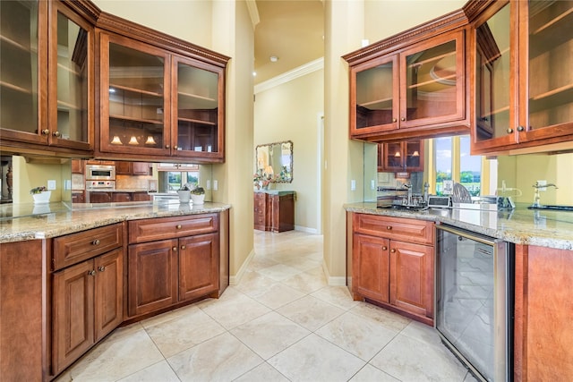 843 Royal Lakes Blvd, Richmond, TX 77469 - kitchen with ornamental molding, light stone counters, wine cooler, light tile patterned floors, and glass insert cabinets