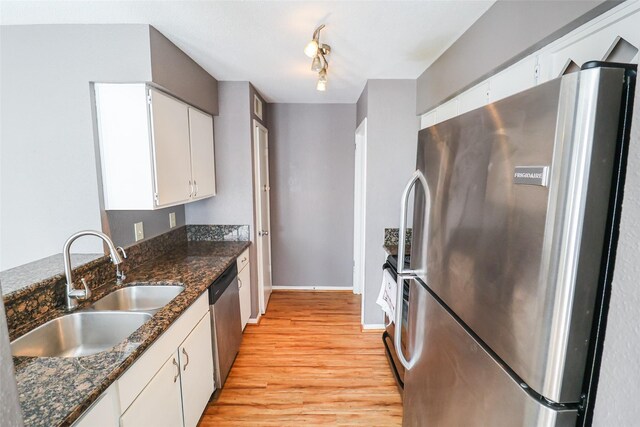 2211 S Kirkwood Rd Unit 51, Houston, TX 77077 - kitchen featuring baseboards, light wood-type flooring, white cabinets, a sink, and stainless steel appliances