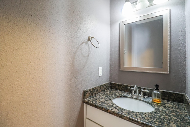 bathroom with vanity and a textured wall