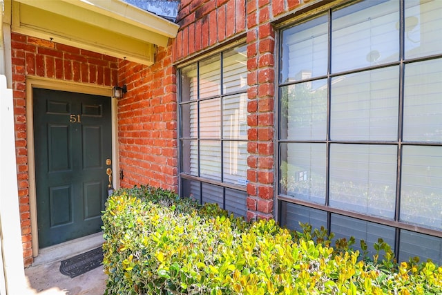 view of exterior entry featuring brick siding