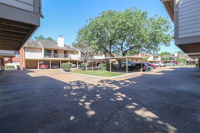 partially covered parking lot featuring a residential view