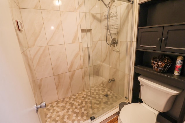 bathroom featuring toilet and a stall shower