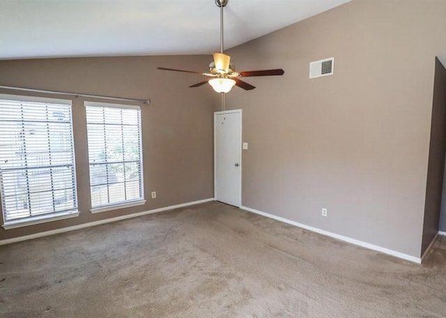 spare room featuring a ceiling fan, visible vents, vaulted ceiling, baseboards, and carpet flooring