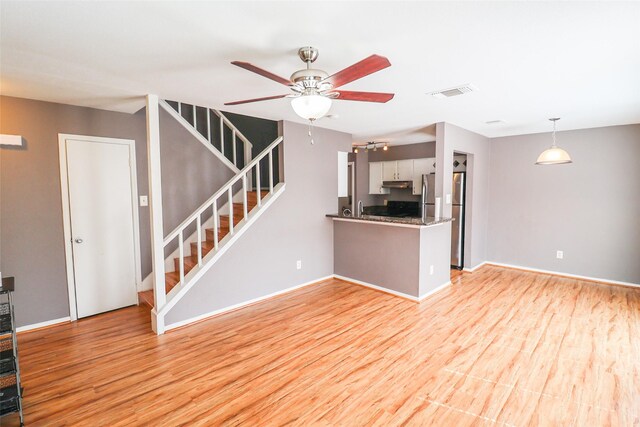 2211 S Kirkwood Rd Unit 51, Houston, TX 77077 - unfurnished living room featuring ceiling fan, light wood-style flooring, baseboards, visible vents, and stairway