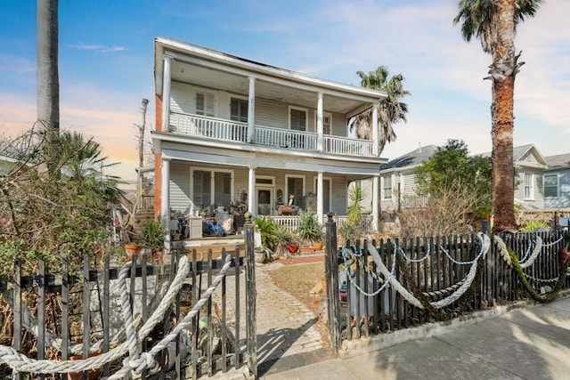 916 Sealy St, Galveston, TX 77550 - view of front of property featuring a fenced front yard, covered porch, a balcony, and a gate
