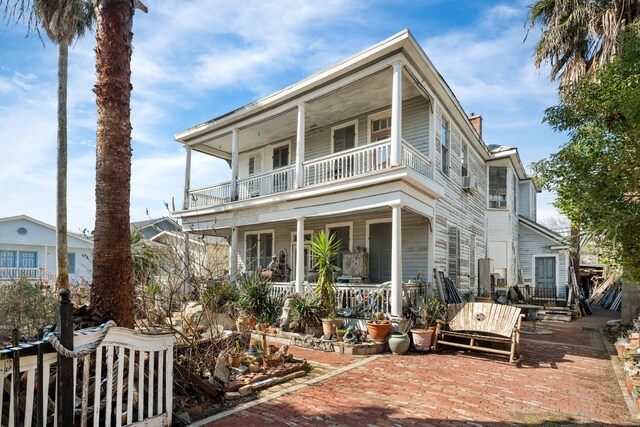 916 Sealy St, Galveston, TX 77550 - rear view of house featuring a balcony, covered porch, and a chimney