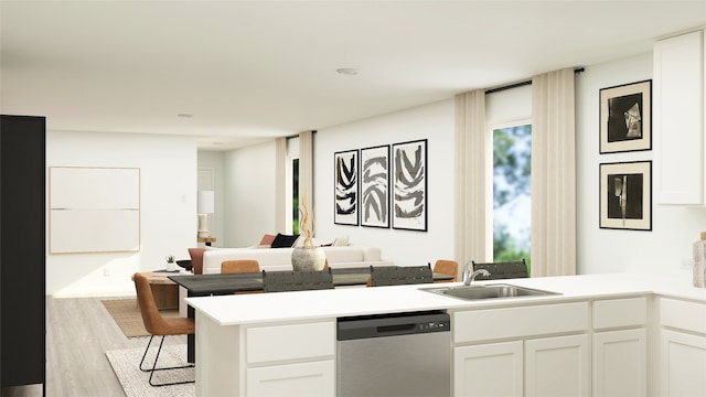 kitchen featuring stainless steel dishwasher, white cabinetry, a sink, a peninsula, and light wood-style flooring