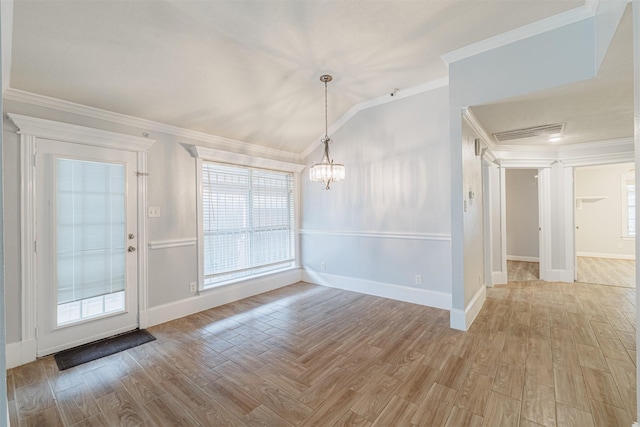 unfurnished dining area with lofted ceiling, crown molding, an inviting chandelier, and wood finished floors