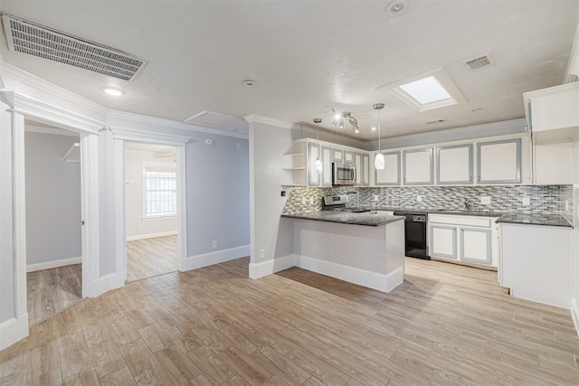 kitchen featuring visible vents, dark countertops, appliances with stainless steel finishes, and a peninsula