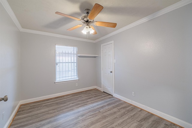 empty room featuring a ceiling fan, wood finished floors, baseboards, and ornamental molding