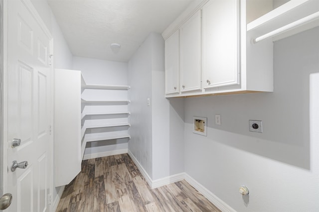 laundry room featuring electric dryer hookup, washer hookup, wood finished floors, cabinet space, and baseboards