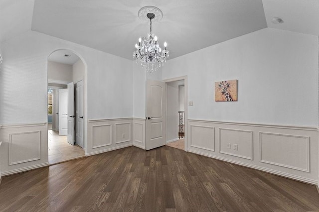 1038 Bolivar Point Ln, Friendswood, TX 77546 - unfurnished dining area featuring arched walkways, dark wood finished floors, wainscoting, a chandelier, and a decorative wall