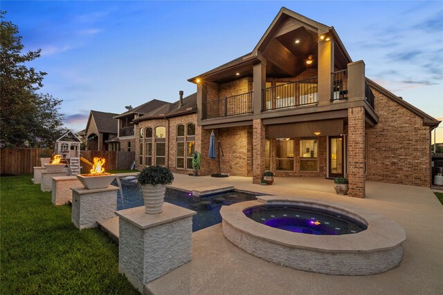 1038 Bolivar Point Ln, Friendswood, TX 77546 - rear view of house featuring a balcony, a fire pit, an in-ground hot tub, and a patio area