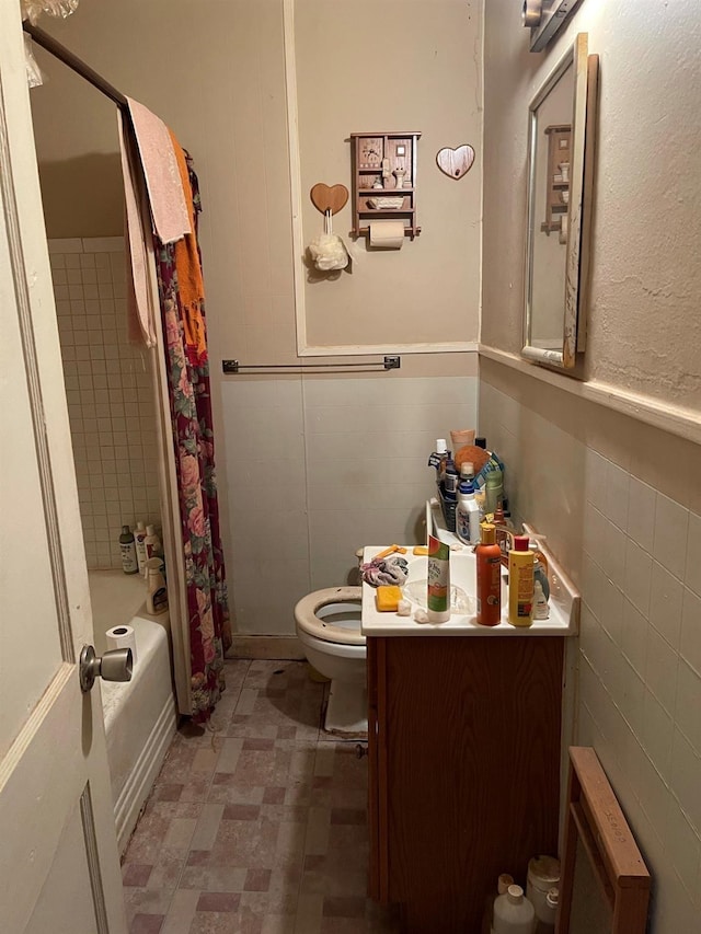bathroom with toilet, radiator, tile walls, shower / bath combination with curtain, and vanity