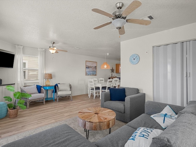 127 Howard, Surfside Beach, TX 77541 - living room with a ceiling fan, wood finished floors, a textured ceiling, and visible vents