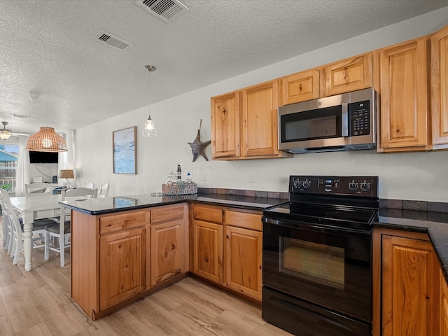 127 Howard, Surfside Beach, TX 77541 - kitchen featuring visible vents, stainless steel microwave, a peninsula, and electric range