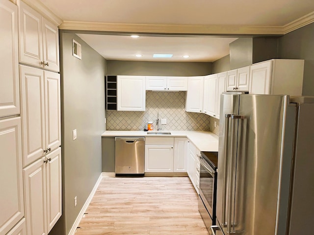 2700 Bellefontaine St Unit A30, Houston, TX 77025 - kitchen with light countertops, backsplash, appliances with stainless steel finishes, light wood finished floors, and a sink