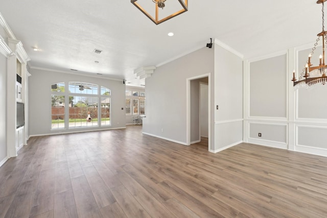 unfurnished living room featuring crown molding, baseboards, wood finished floors, and ceiling fan with notable chandelier