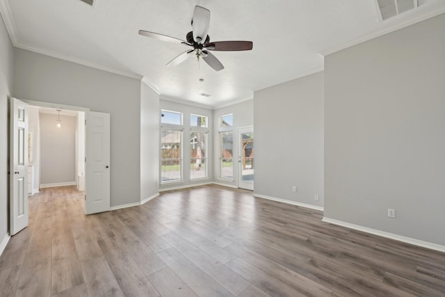 empty room with ornamental molding, ceiling fan, and wood finished floors