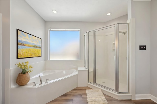 full bath with a garden tub, a shower stall, and wood finished floors