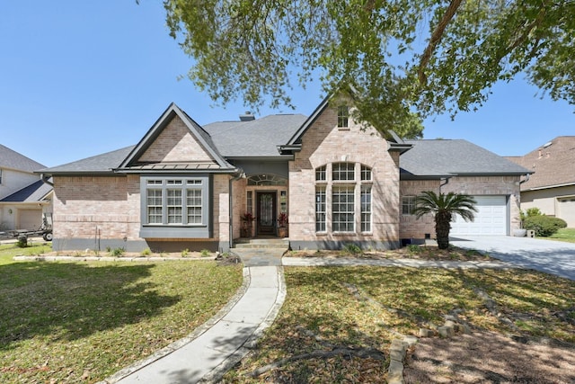 view of front facade featuring concrete driveway, a shingled roof, a front yard, brick siding, and a garage