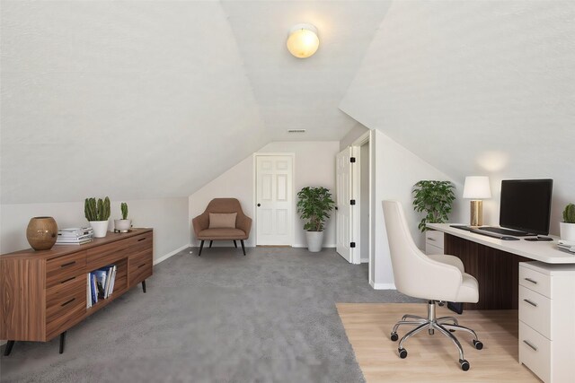 office featuring light carpet, lofted ceiling, and baseboards