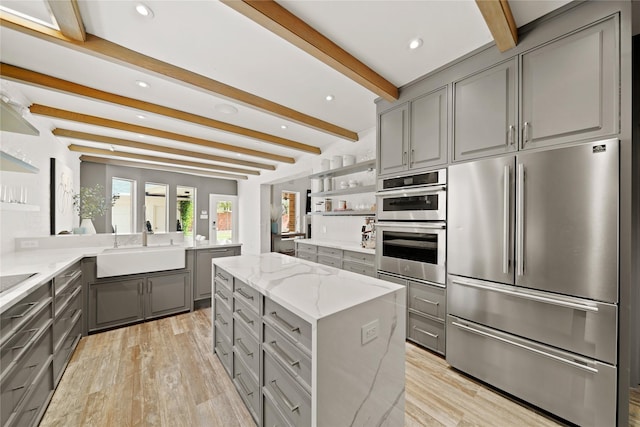 9219 Hummingbird Ln, Missouri City, TX 77459 - kitchen with gray cabinetry, a sink, open shelves, light stone counters, and stainless steel appliances