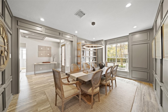 9219 Hummingbird Ln, Missouri City, TX 77459 - dining room featuring visible vents, recessed lighting, a decorative wall, and light wood-style floors