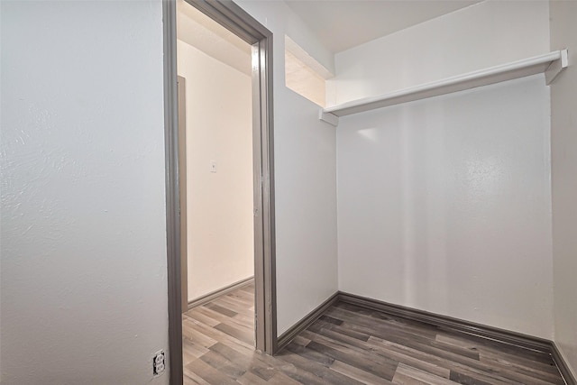 walk in closet with wood finished floors