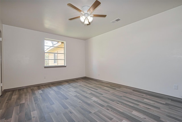 spare room featuring baseboards, visible vents, wood finished floors, and ceiling fan