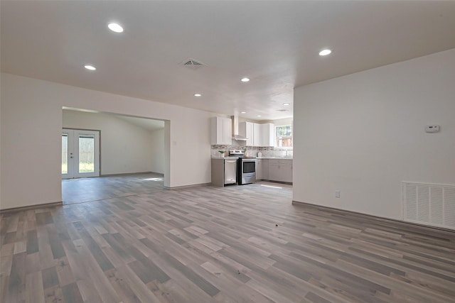 unfurnished living room featuring visible vents, french doors, recessed lighting, and wood finished floors