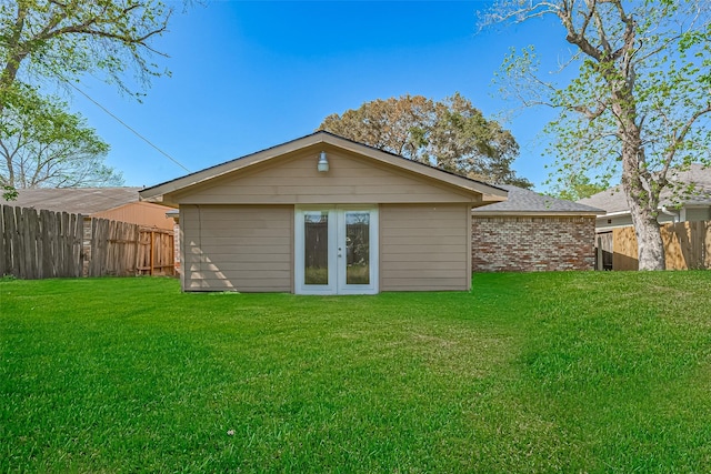 rear view of house featuring fence, brick siding, and a yard